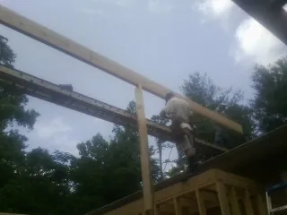Carpenter setting a ridge beam over a new addition frame — Ice Dam Removal by Roofing Brothers in North Providence