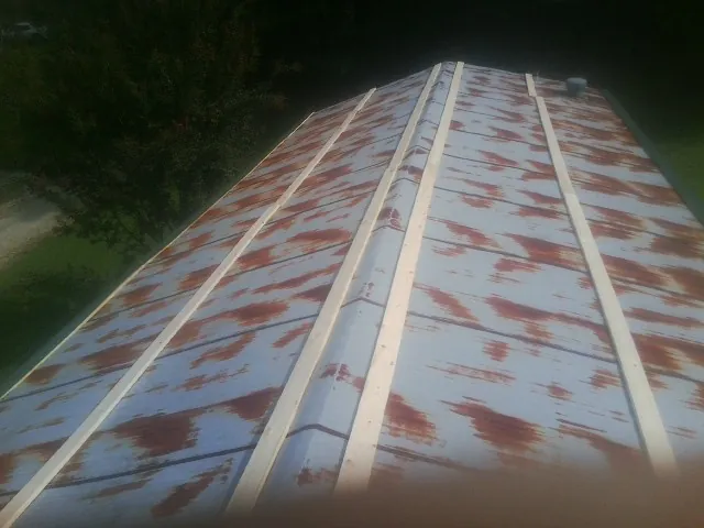 Rusted metal roof panels with new wood purlins before replacement — Storm Damage Roof Repair in North Providence by Roofing Brothers