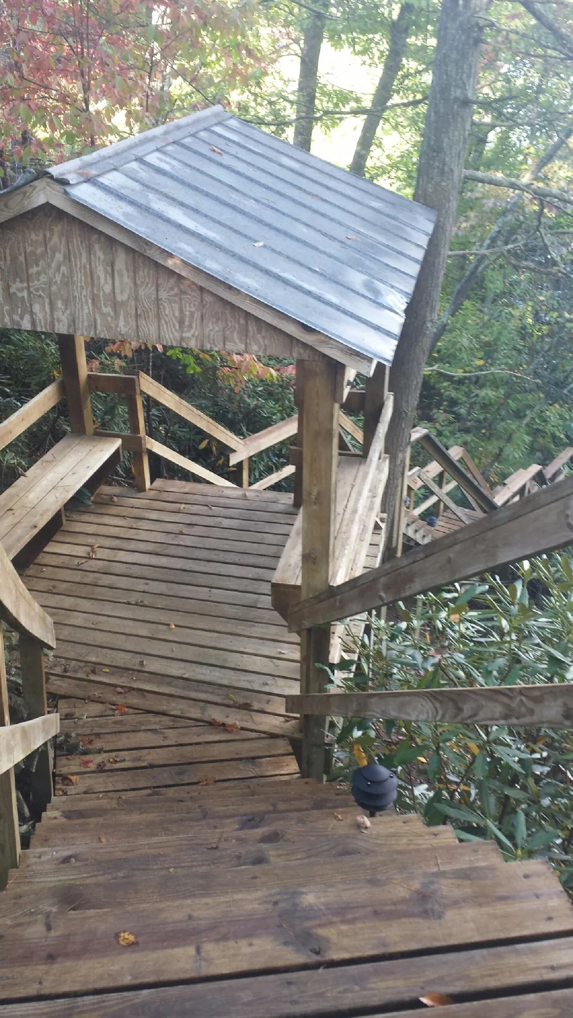 Metal roofed shelter over wooden steps on a wooded walkway — Skylight Repair & Installation work by our crew in North Providence