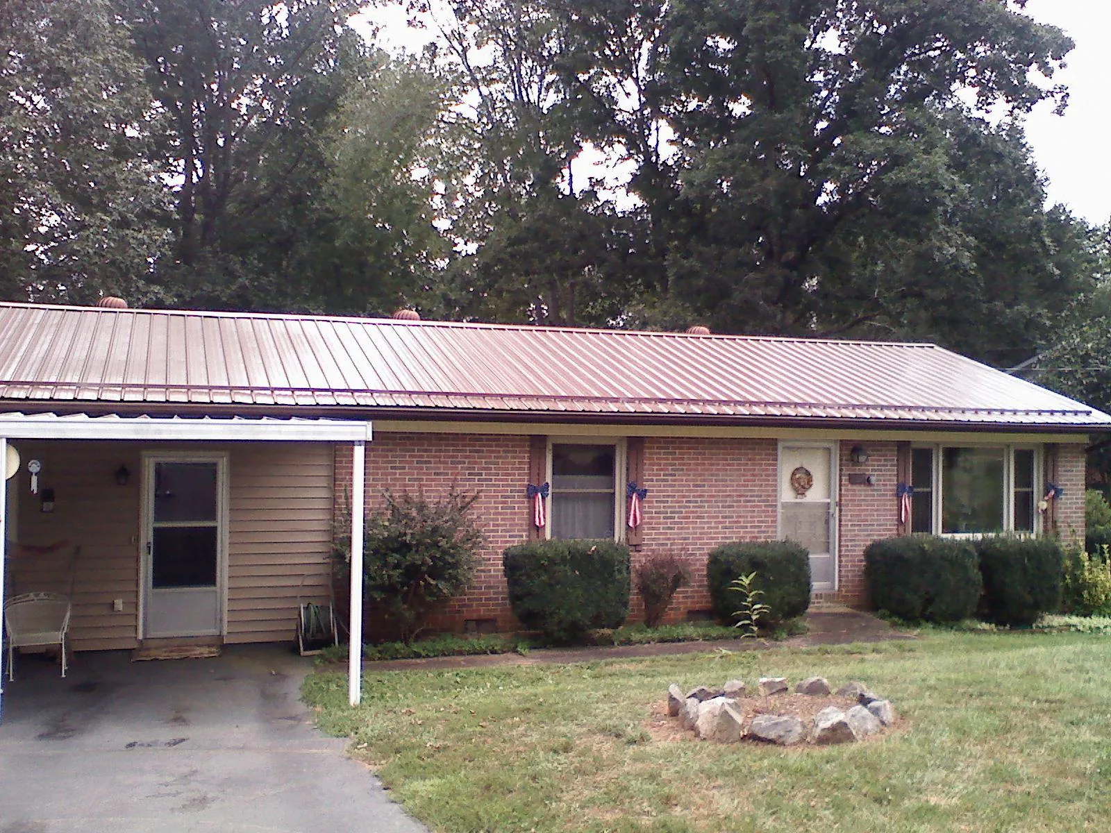 Bronze metal roof and carport on a brick ranch home — Roof Repair work by our crew in North Providence